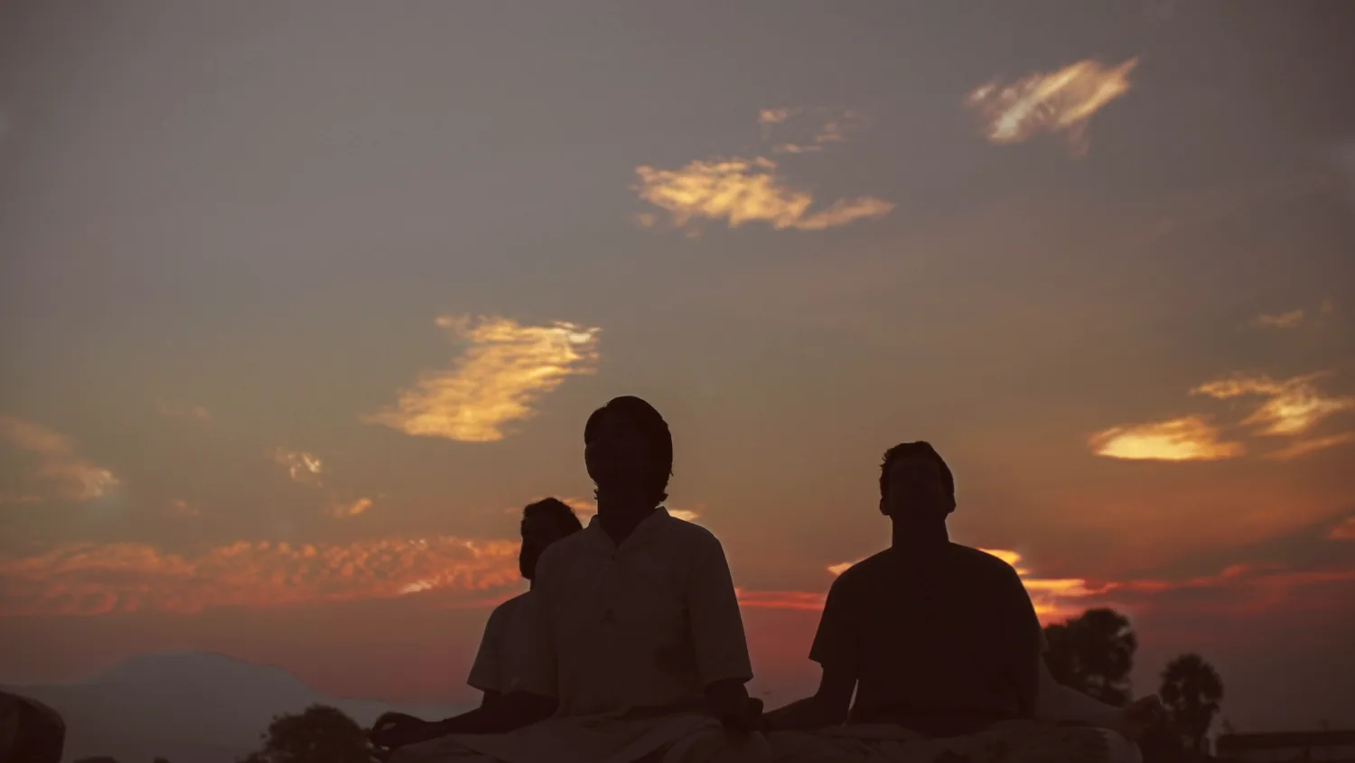 A yogi arched into a backbend against the Rishikesh sunrise