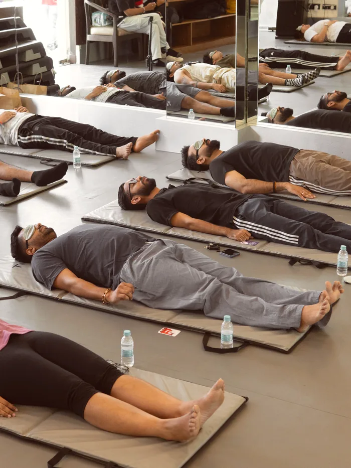 A room of people lying down mid-breathwork