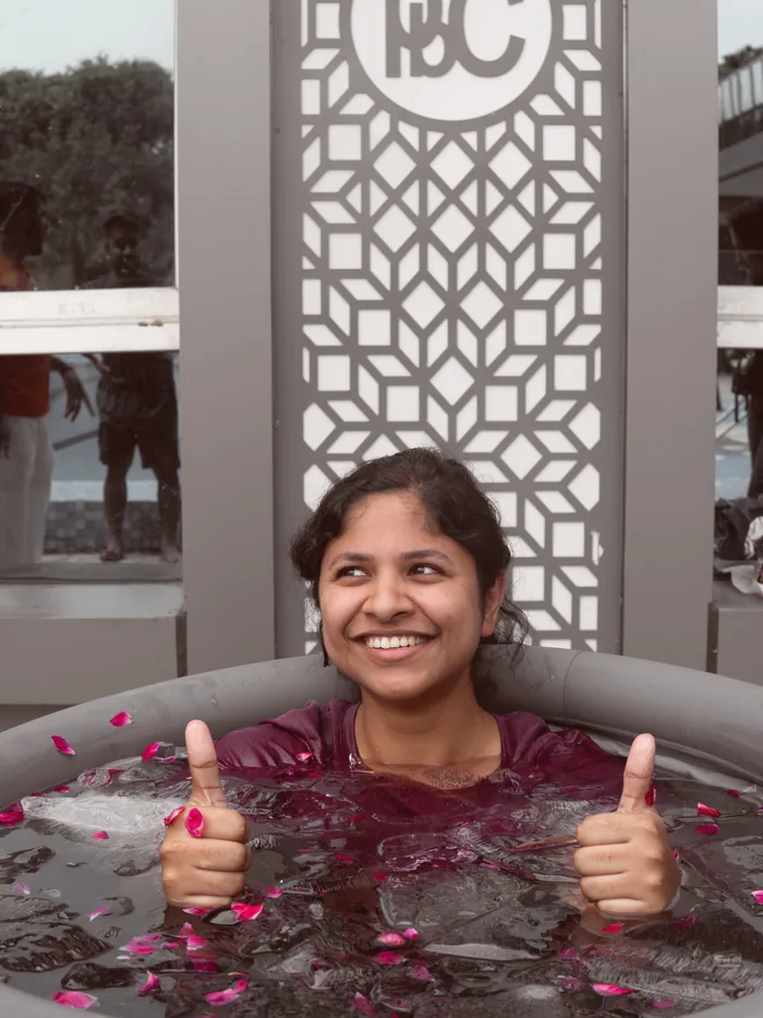 A guest laughing with both thumbs up after her ice bath