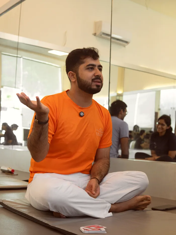 The teacher mid-sentence, one hand open, describing the practice