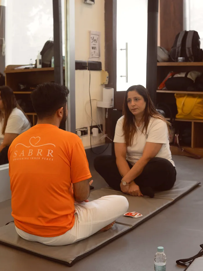Two people sitting together on neighbouring mats