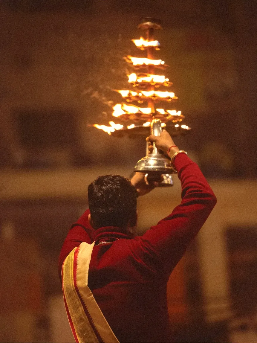 A priest raising the tiered lamp during the evening Ganga aarti