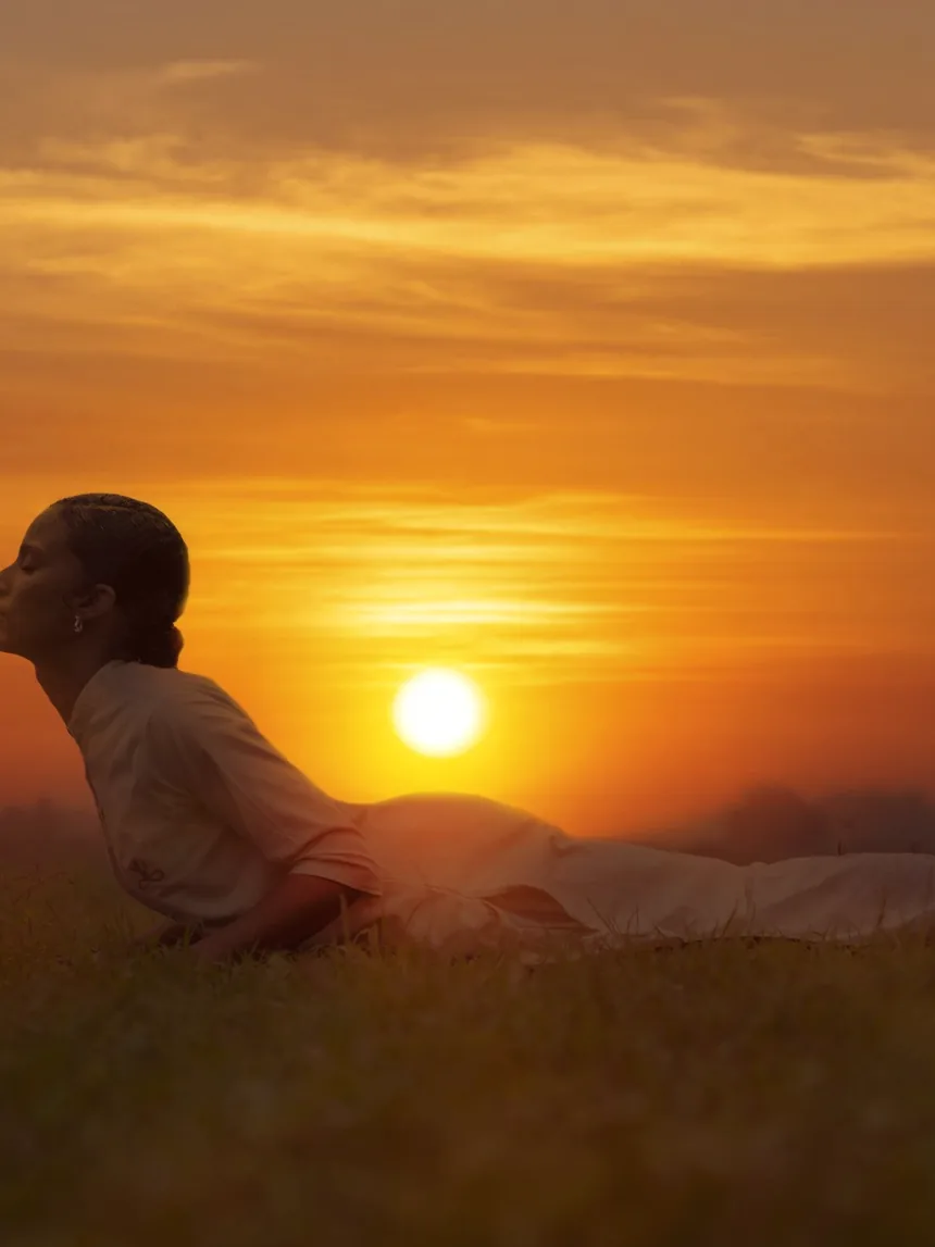 A practitioner arching into a backbend as the sun comes up