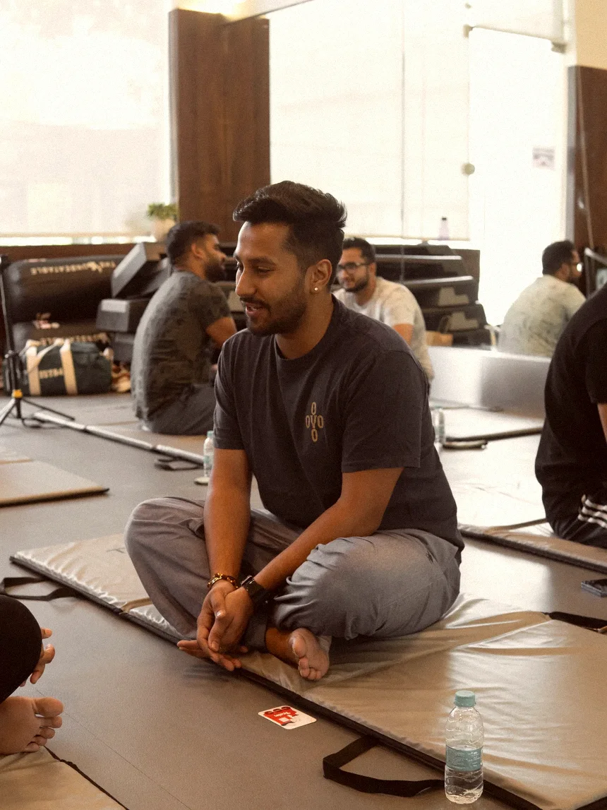 A guest seated on a mat, mid-conversation, being listened to