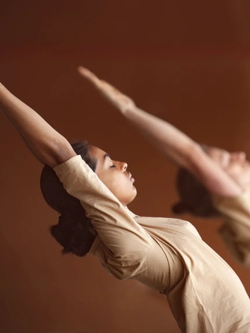 Two practitioners holding a balancing Hatha posture